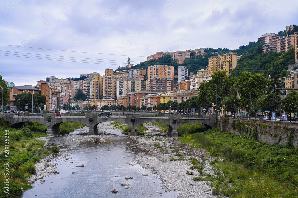 Genoa, Italy - June, 12, 2018:  residential district of Genoa on an embankment of river, Italy