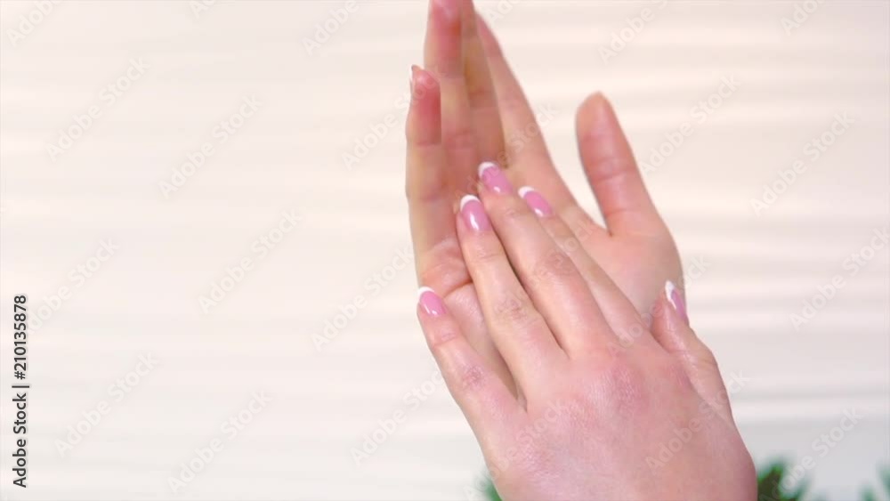 Beautiful woman applying moisturizing cream on her hands. Spa and manicure concept. Slow motion 240 fps UHD 4K video Beautiful woman applying moisturizing cream on her hands. Spa and manicure concept. Slow motion 240 fps UHD 4K video