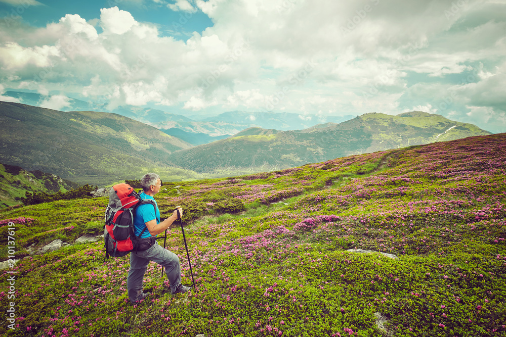 Fototapeta premium Man with red backpack enjoying landscape on cliff solo traveling healthy lifestyle concept active summer vacations