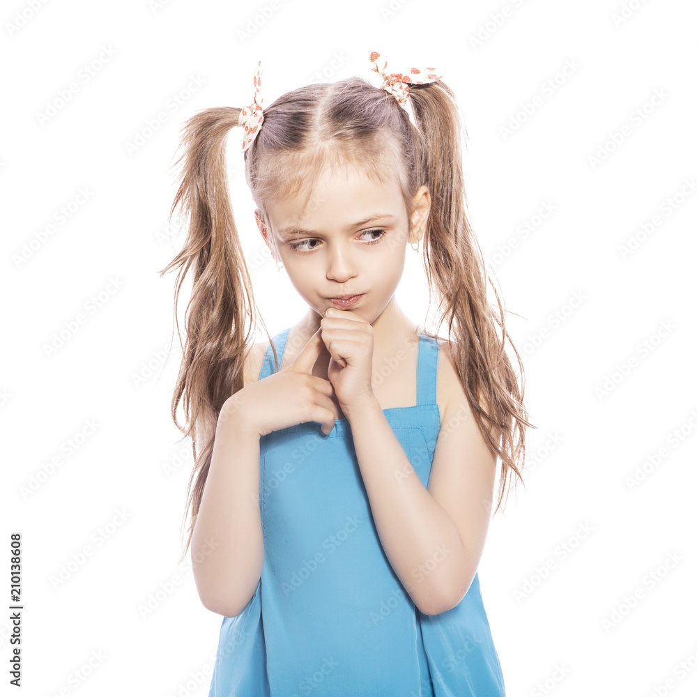Young seven years old brunette girl in blue dress on a white isolated background. Thoughtful, thinking emotions on her face Young seven years old brunette girl in blue dress on a white isolated background. Thoughtful, thinking emotions on her face