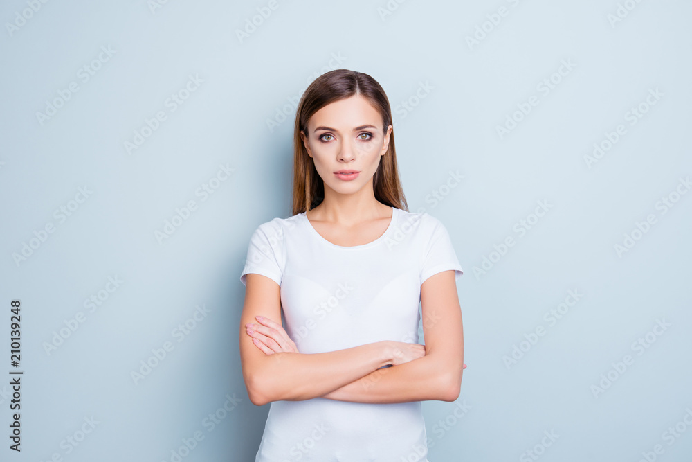 Portrait of perfect cute girl in white t-shirt having holding arms crossed isolated on grey background looking at camera