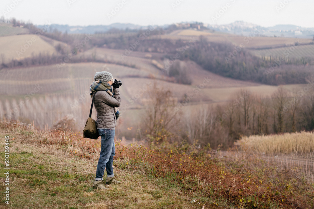 Woman taking pictures in the countryside