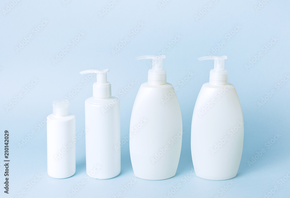 Cosmetic bottle containers on a blue minimalistic background flat lay. Blank label for branding mock-up. Natural beauty product concept. Cosmetic bottle containers on a blue minimalistic background flat lay. Blank label for branding mock-up. Natural beauty product concept.