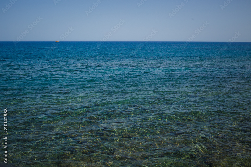 Stony sea shore, blue water and sky Stony sea shore, blue water and sky