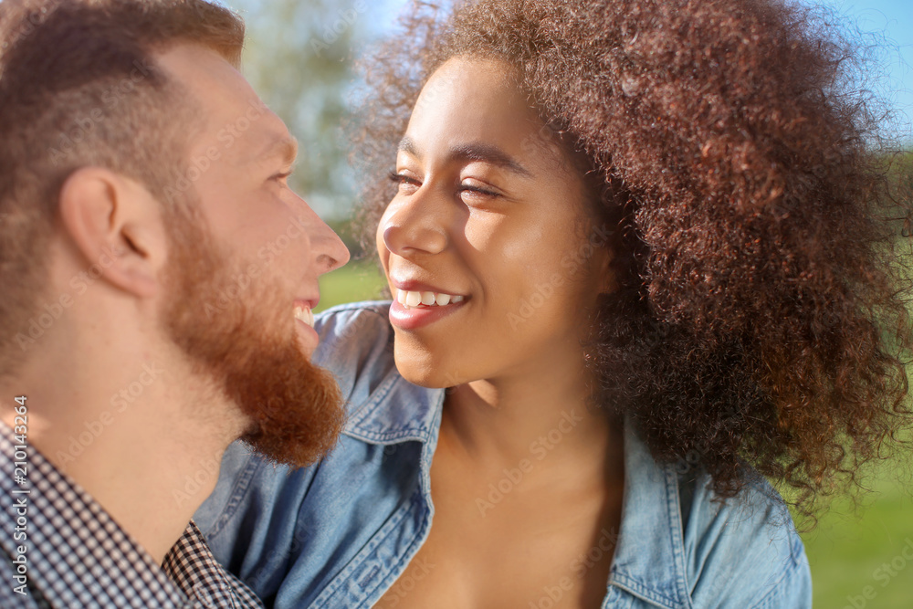 Young loving interracial couple outdoors on spring day Young loving interracial couple outdoors on spring day