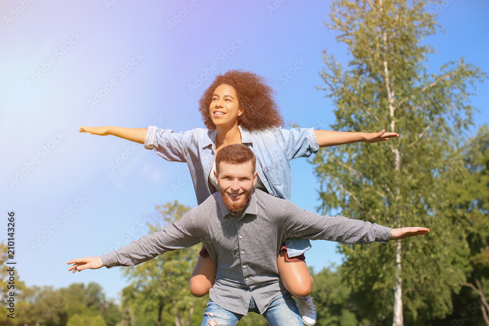 Young loving interracial couple having fun outdoors on spring day Young loving interracial couple having fun outdoors on spring day