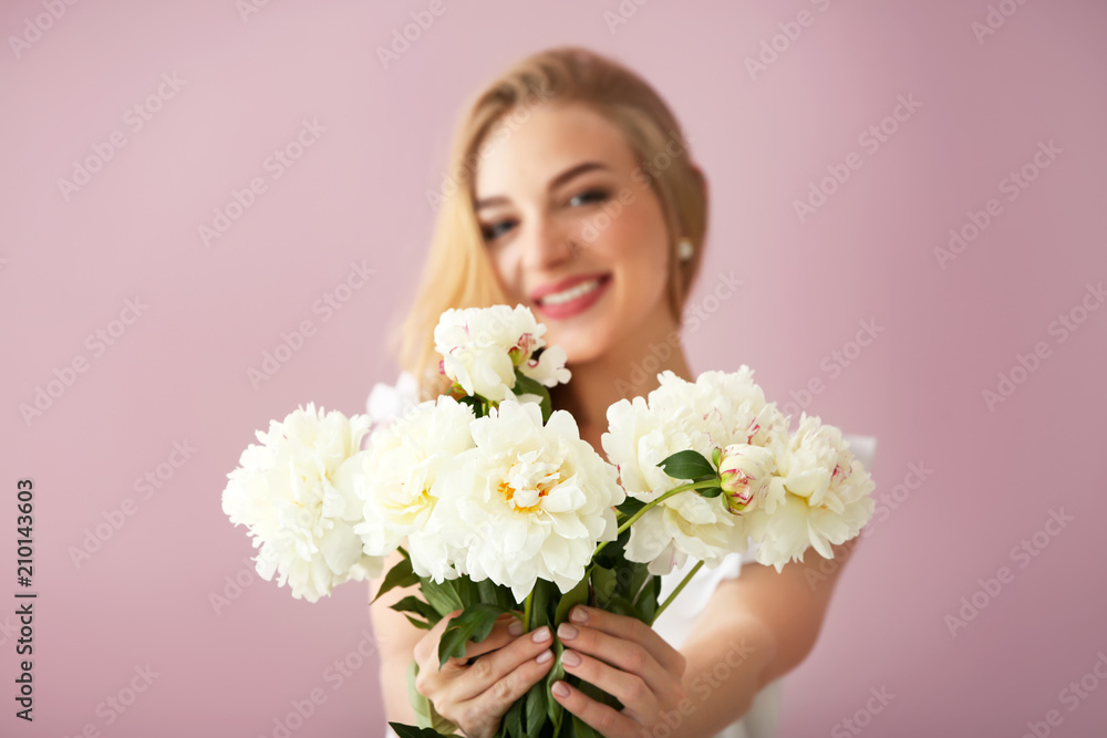 Attractive young woman with beautiful flowers on color background