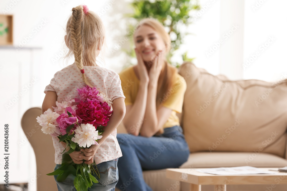 Cute little girl hiding bouquet of flowers for mother behind her back Cute little girl hiding bouquet of flowers for mother behind her back