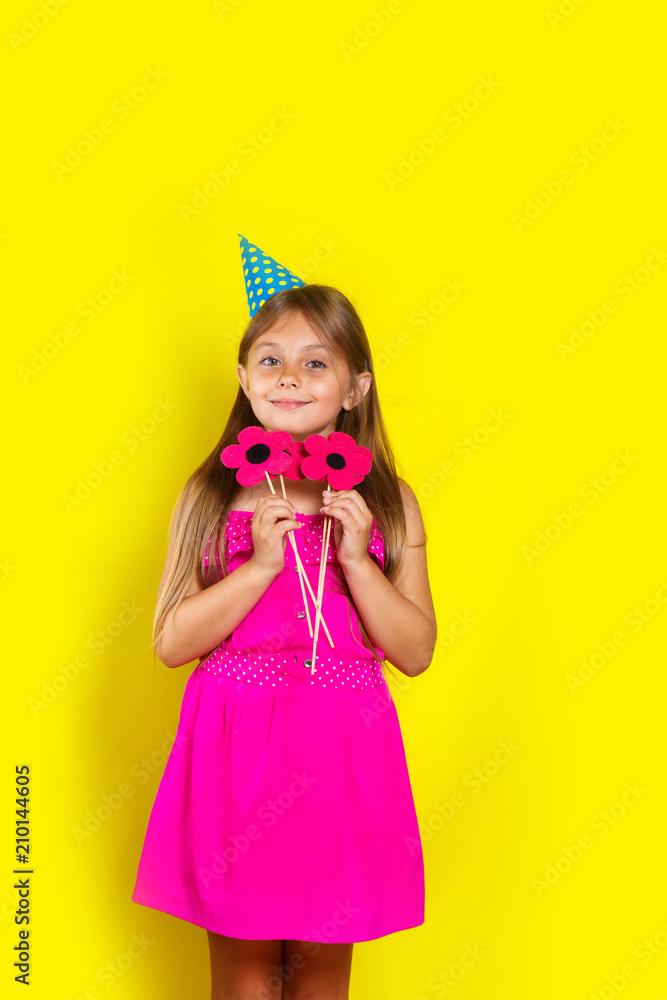 Studio portrait of a little girl wearing a party hat on her birthday.