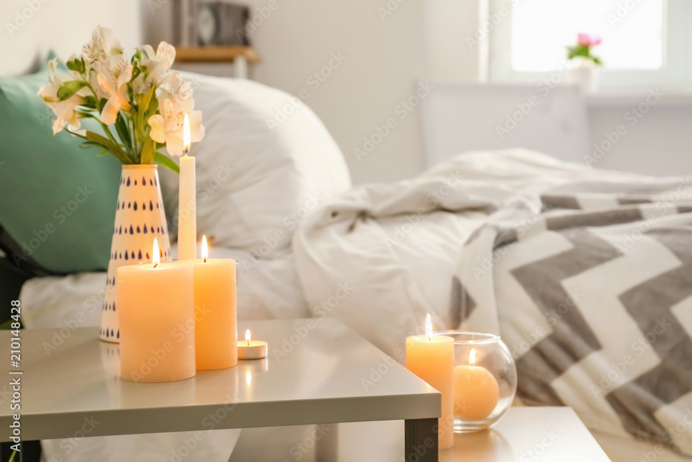 Burning wax candles on table in bedroom Burning wax candles on table in bedroom