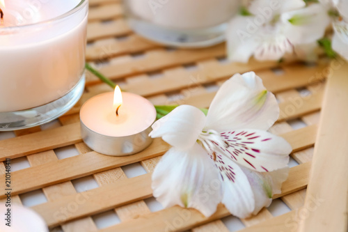 Burning wax candles with flower on table