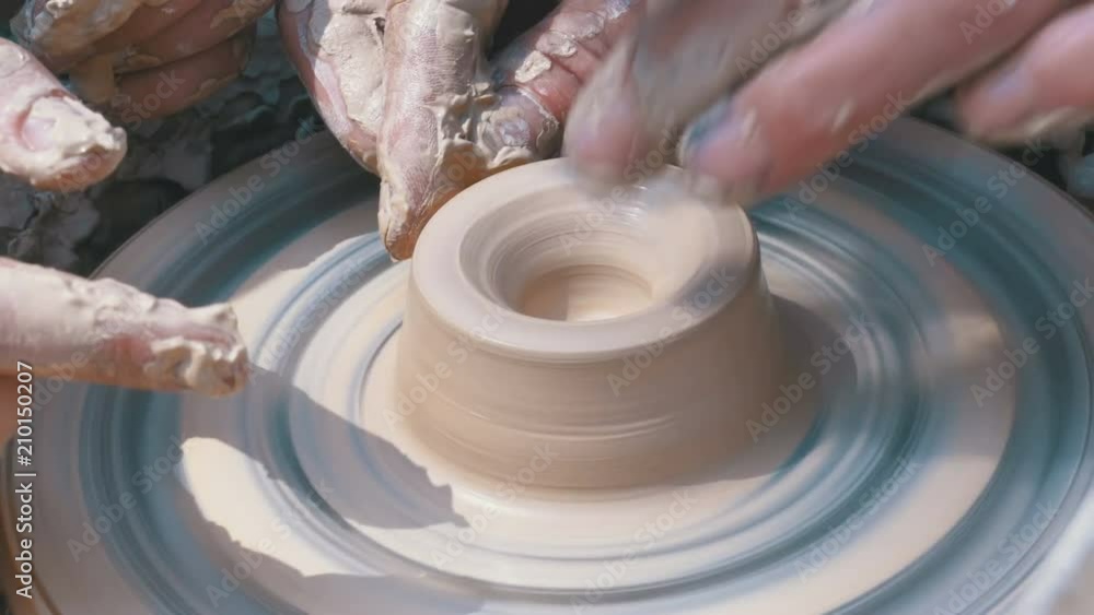 Potter's Hands Work with Clay on a Potter's Wheel. Potter shapes the
