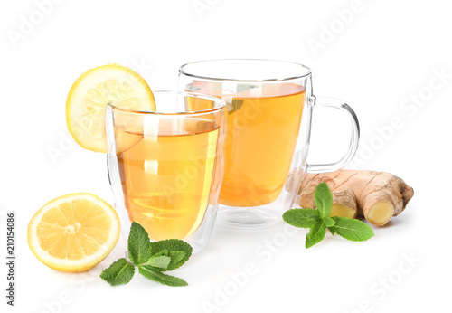 Cups of delicious tea with ginger and lemon on white background