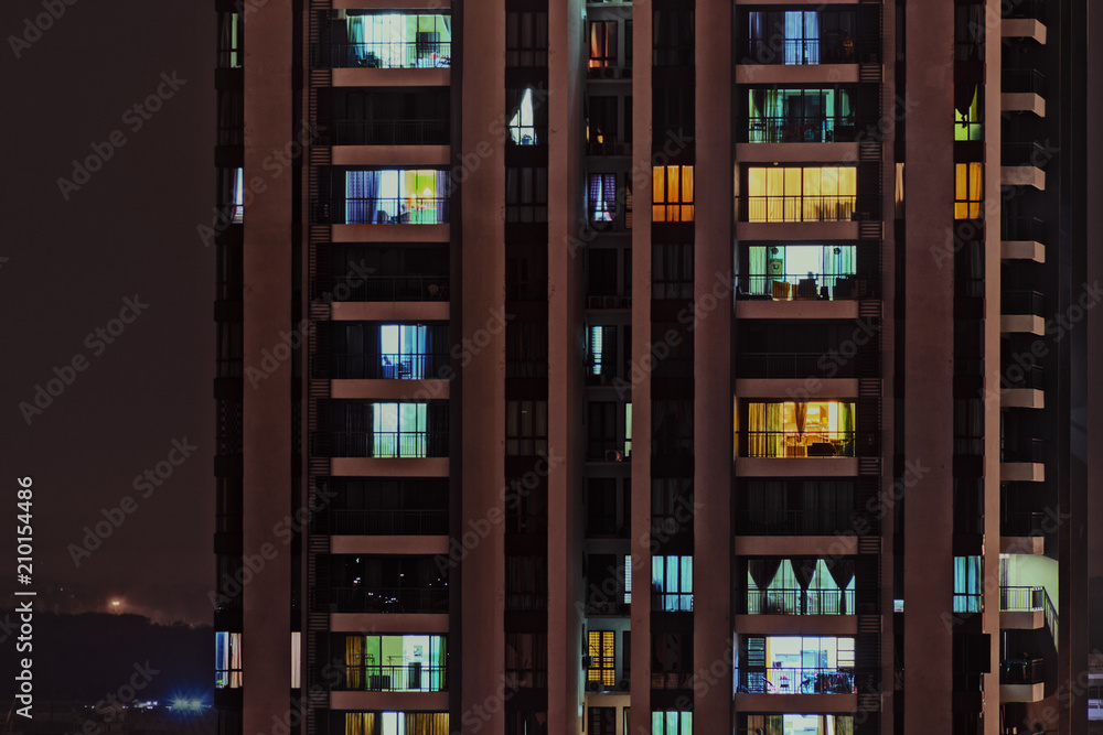 Night Life In Big City Front View Of Modern High Rise Building With Windows Of Cozy Apartments In Which Light Shines And People Doing Routine Things Toned With Instagram Filters Stock Photo