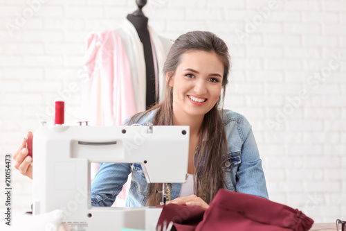Young female tailor using s...