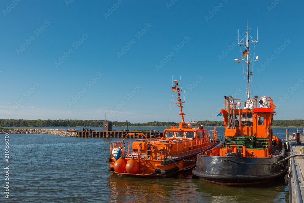 Fototapeta premium Zwei orange Boote liegen am Hafen 