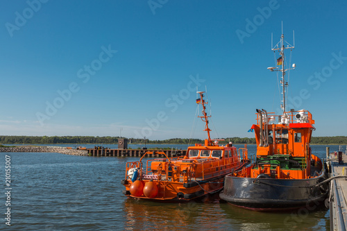 Zwei orange Boote liegen am Hafen 