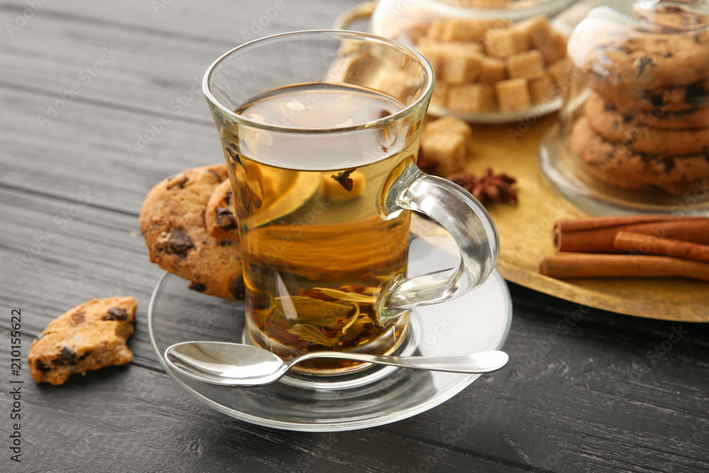 Cup of hot aromatic tea with cookies on wooden table Cup of hot aromatic tea with cookies on wooden table