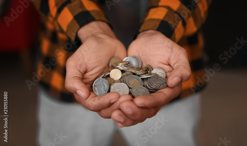 African-American man with handful of coins, closeup. Savings concept