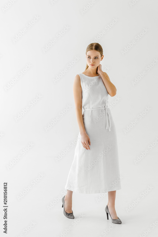 beautiful woman in linen white dress posing with hand on neck isolated on grey background beautiful woman in linen white dress posing with hand on neck isolated on grey background