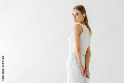 beautiful woman in linen white dress posing isolated on grey background