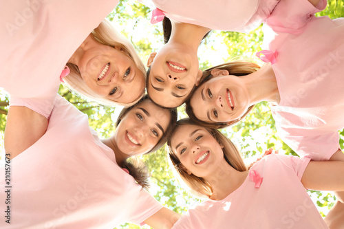 Beautiful women of different ages with pink ribbons outdoors. Breast cancer concept