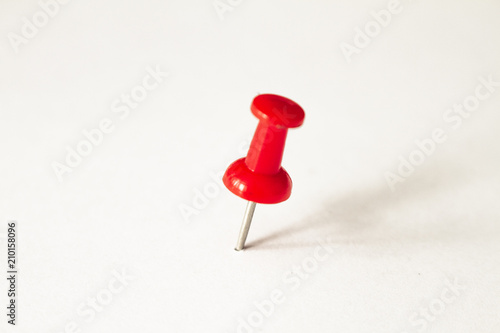 Red pushpin on white background