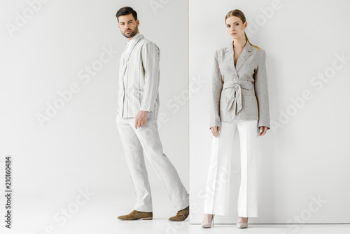 Foto young male and female models in vintage clothes looking at camera on white