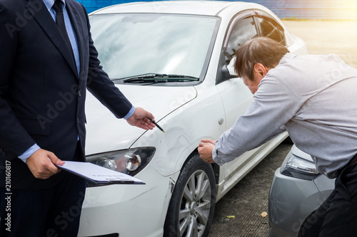 Insurance Agent examine Damaged Car and filing Report Claim Form after accident, Traffic Accident and insurance concept © Freedomz