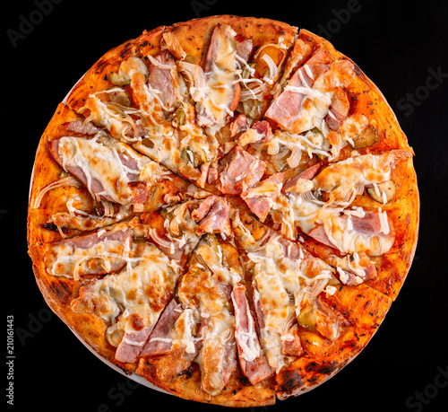 Fresh pizza with meat beaf chicken pork, tomatoes, vegetables, ushrooms on dark black background closeup photo