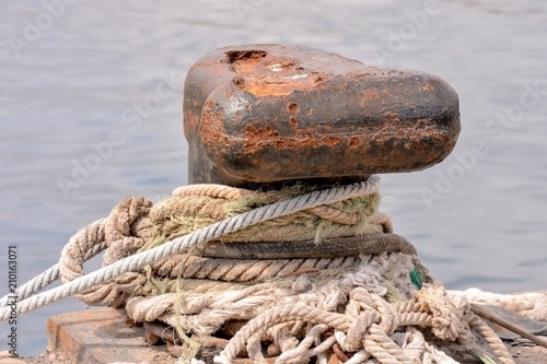 Rusty metal mooring bolard for big ship photo