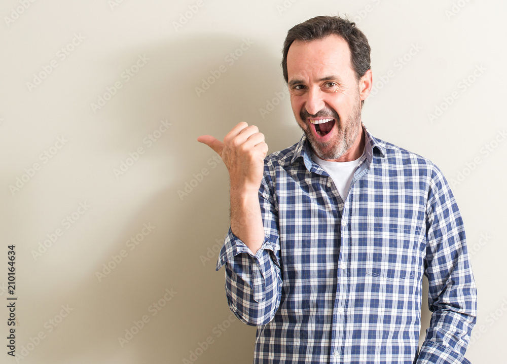 Senior man pointing with hand and finger up with happy face smiling