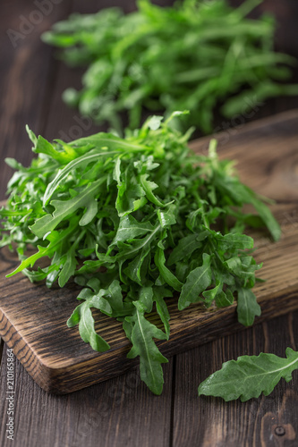 Fresh green arugula in bowl on table. Arugula rucola for salad. Close up of fresh green healthy food. Diet concept.