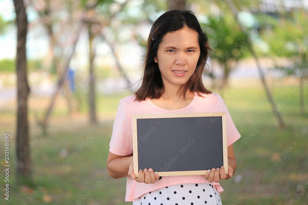 Fototapeta premium Asian women are pregnant for about twelve weeks to holding a blank blackboard.