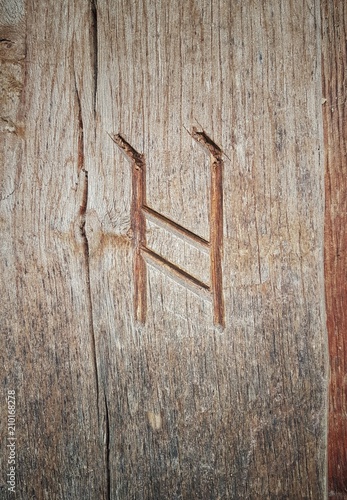 The Viking rune symbol for H carved into wood.