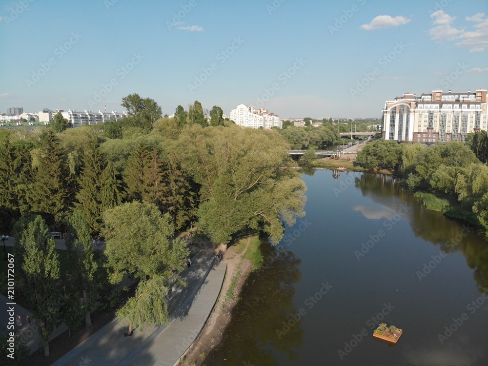 flight over the river in a city park among trees