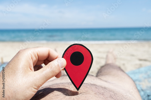 man with a red marker in his hand on the beach