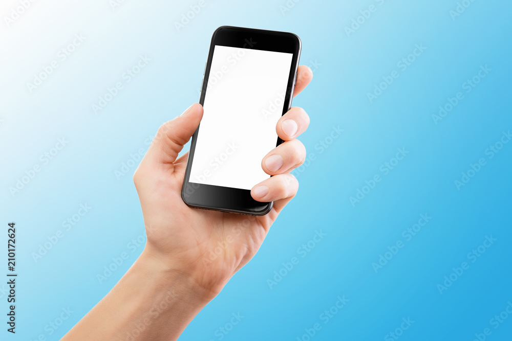 Mockup of male hand holding black cellphone isolated at blue background.