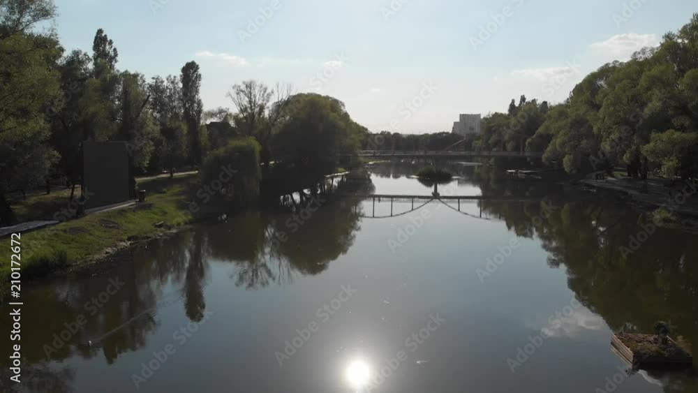 flight over the river in a city park among trees flight over the river in a city park among trees