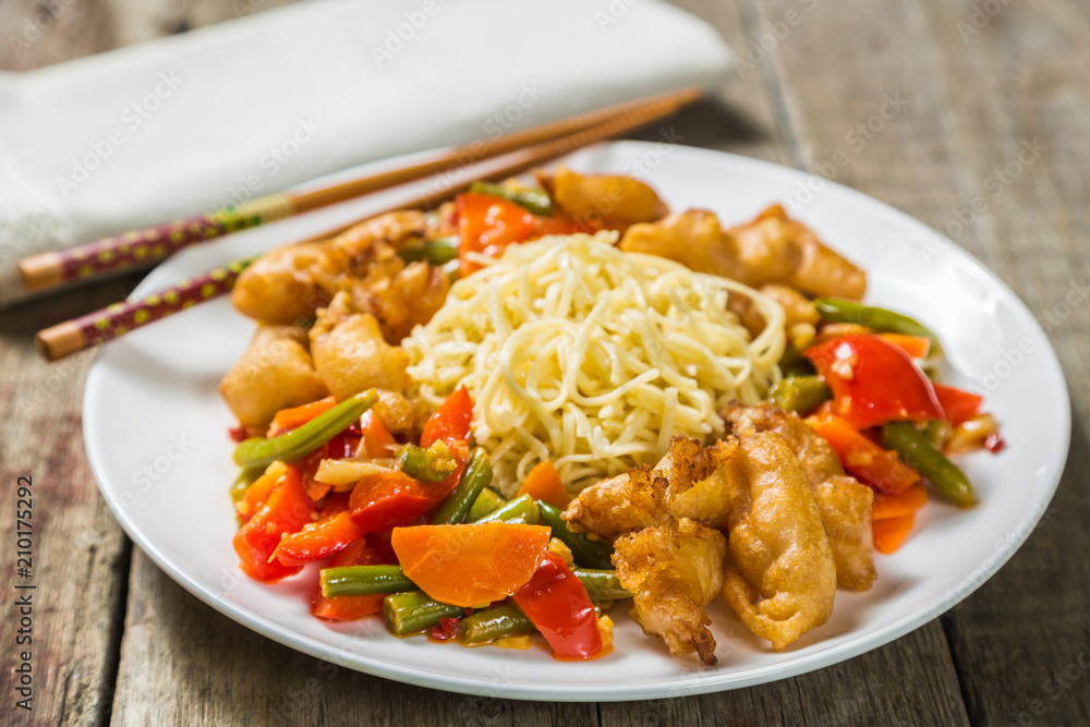 Deep-fried squid with vegetables in garlic sauce with noodles. Concept of Chinese cuisine.