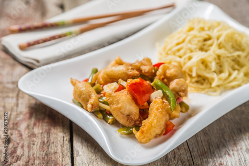 Deep-fried squid with vegetables in garlic sauce with noodles. Concept of Chinese cuisine. 