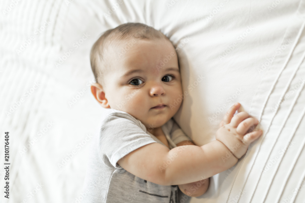 Adorable baby boy in white bedroom in morning Adorable baby boy in white bedroom in morning