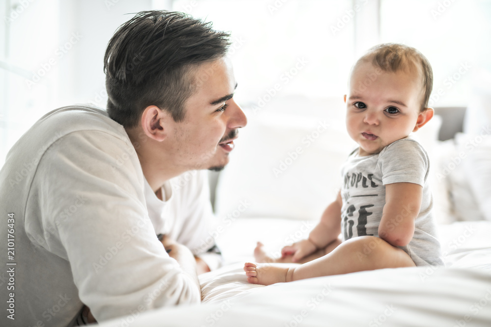 Obraz premium Father and adorable baby on bed