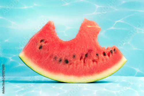 A piece of a bitten watermelon on a blue background.