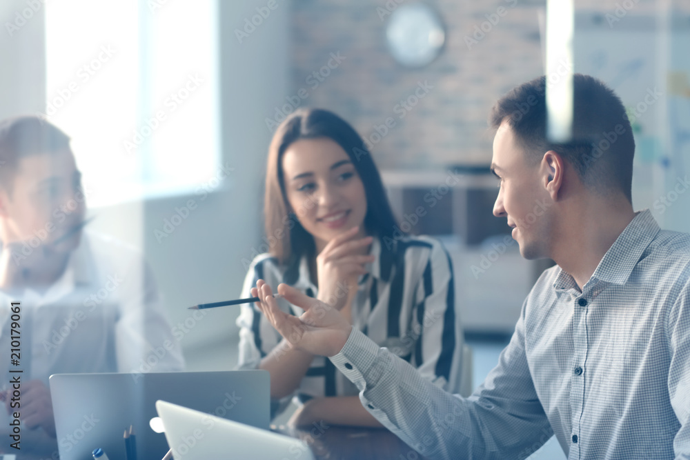 Fototapeta premium Young people having business meeting in office, view through glass