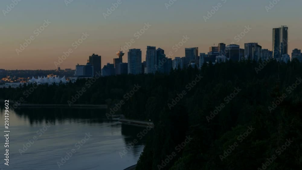 Time lapse of sky over downtown city skyline of Vancouver BC Canada and Stanley Park with water reflection during sunrise one summer morning 4k UHD Time lapse of sky over downtown city skyline of Vancouver BC Canada and Stanley Park with water reflection during sunrise one summer morning 4k UHD