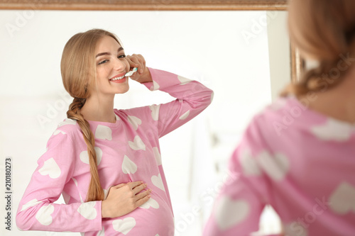 Young pregnant woman cleani...