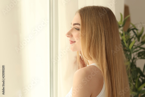 Young woman standing near w...