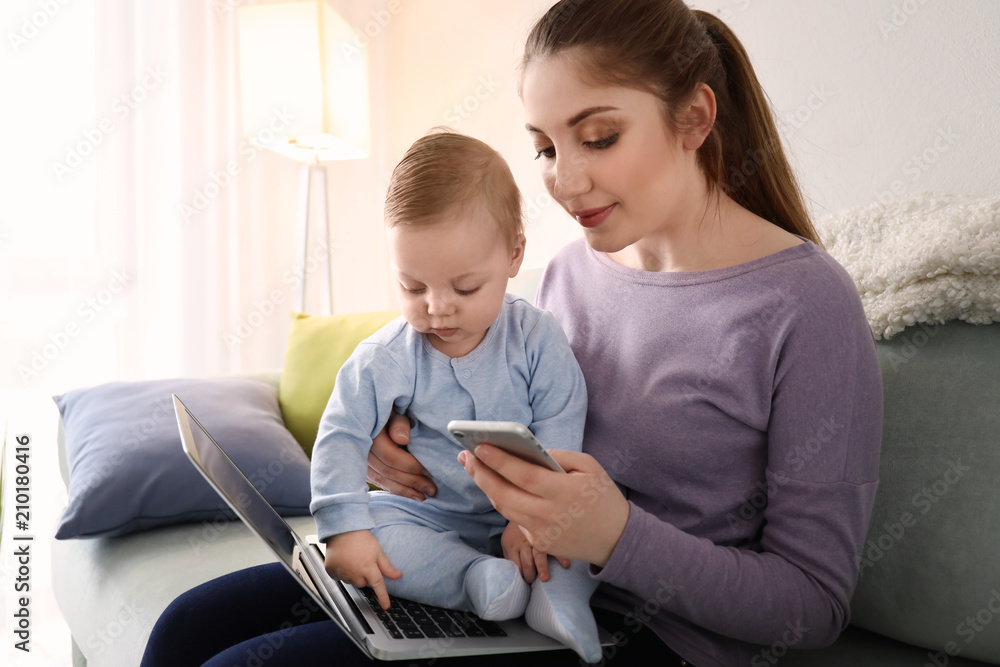 Young mother with baby working at home Young mother with baby working at home
