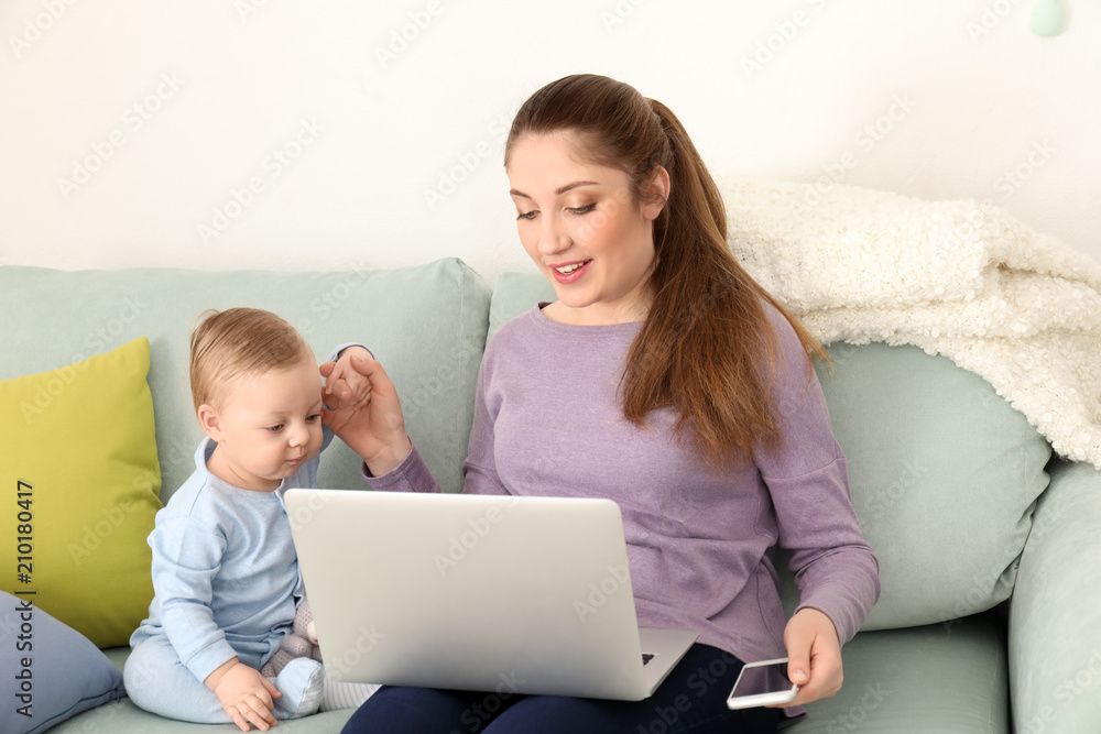 Young mother with baby working at home Young mother with baby working at home